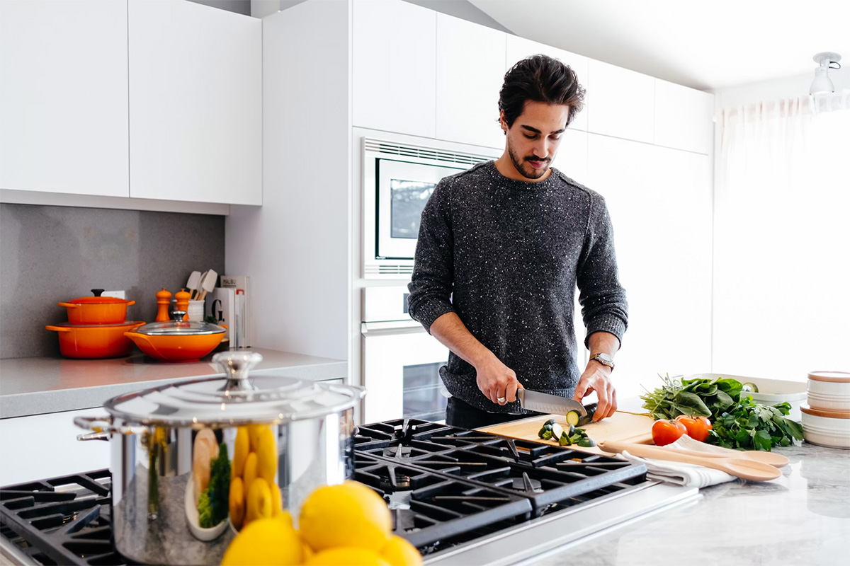 hombre preparando alimentos en una cocina contemporánea