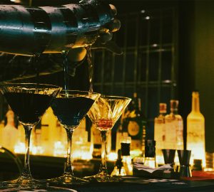 cocteles sobre barra iluminación tenue bar elegante coctelería de autor