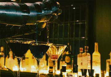 cocteles sobre barra iluminación tenue bar elegante coctelería de autor