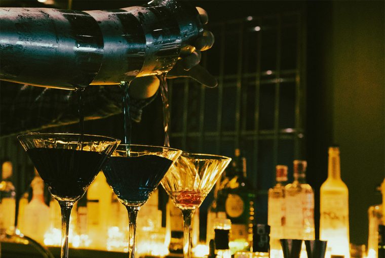 cocteles sobre barra iluminación tenue bar elegante coctelería de autor